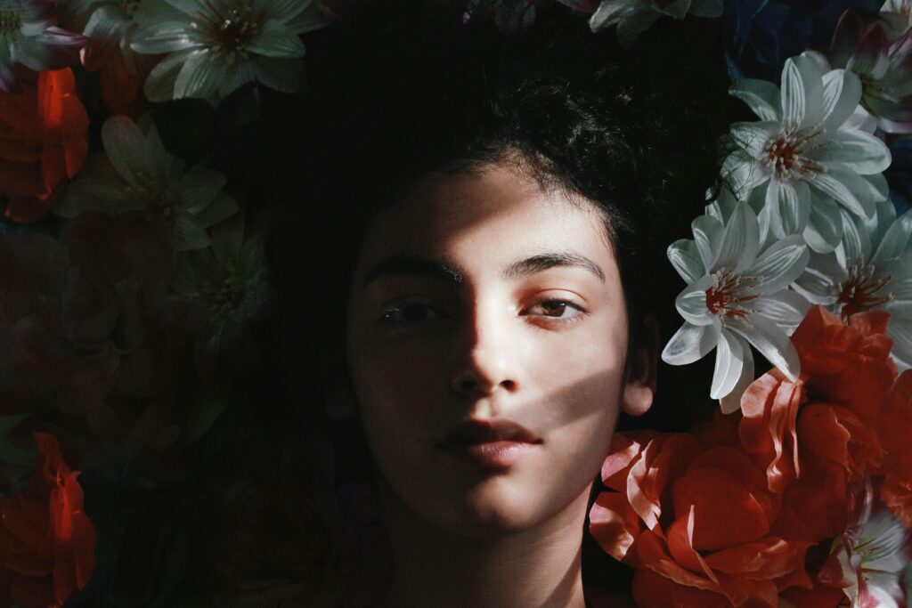 Captivating portrait of a woman with deep shadow and colorful flowers in Barranquilla.