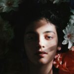 Captivating portrait of a woman with deep shadow and colorful flowers in Barranquilla.