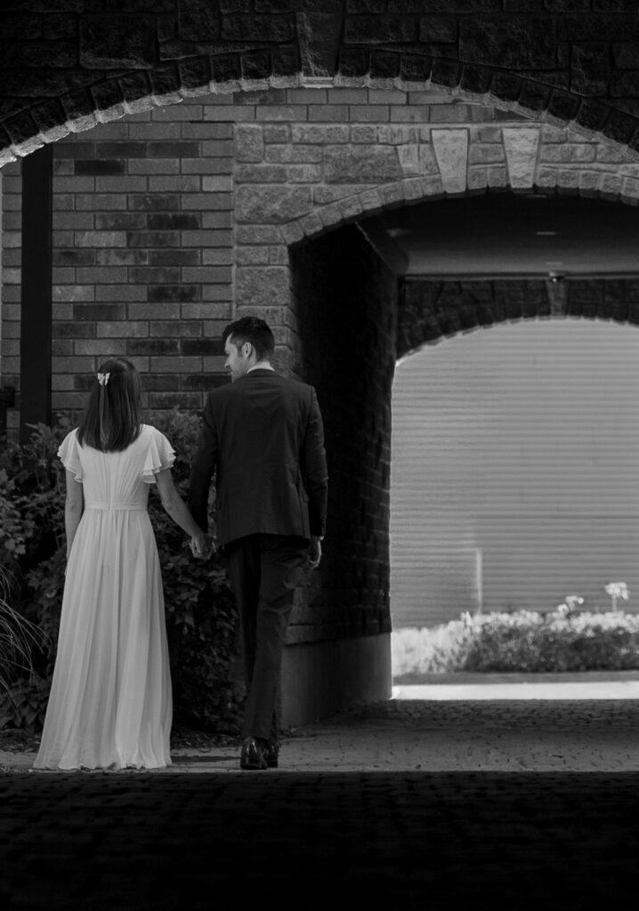 black and white photo of a husband and wife walking away in a tunnel